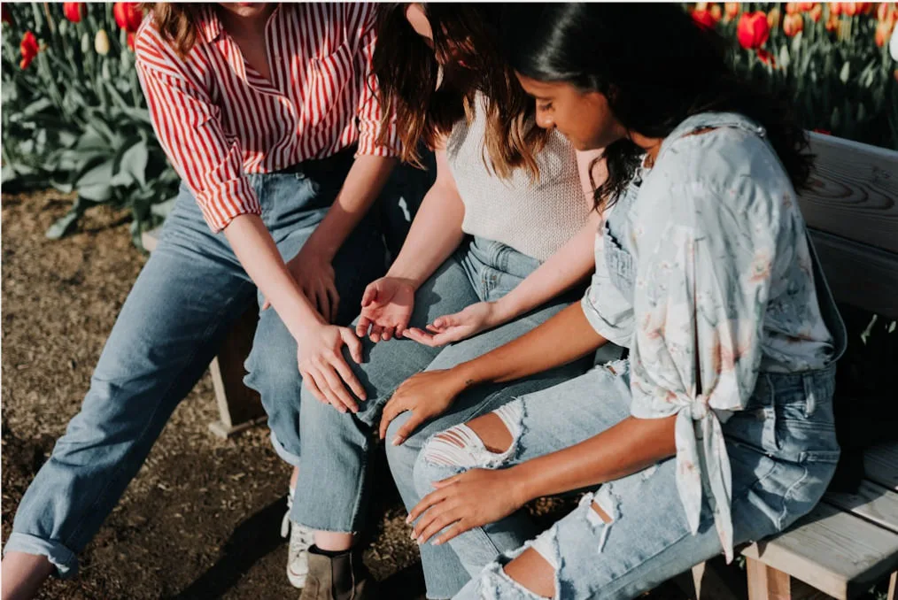 a group of women sitting on a bench