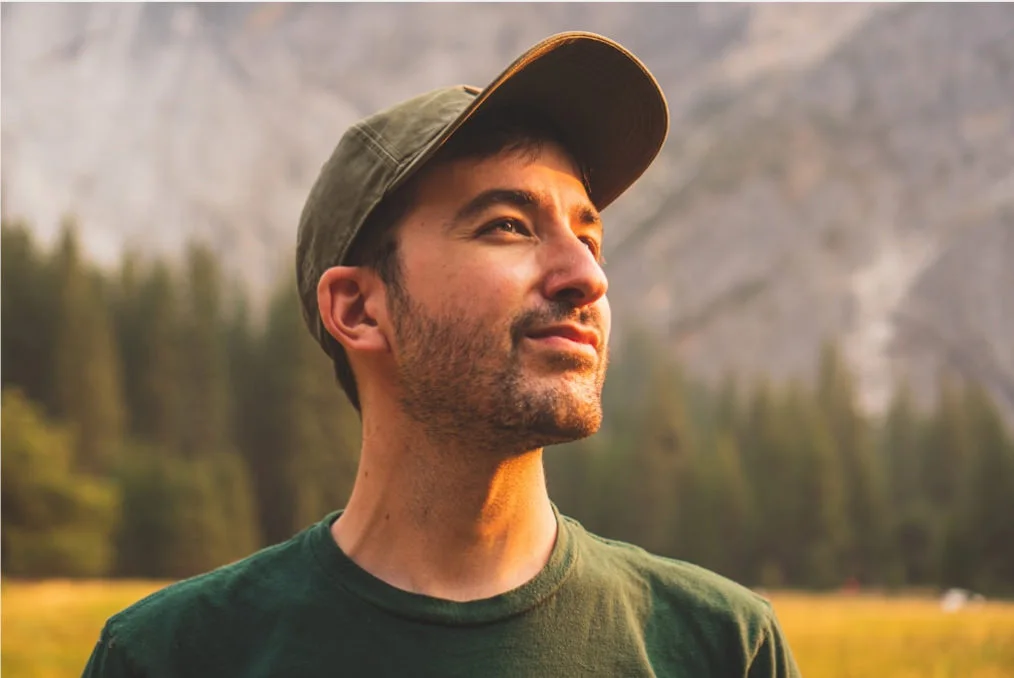 a picture of a man with a mountain range on the background