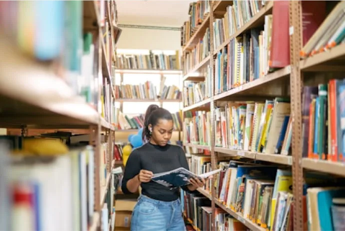 a young woman reading in a library