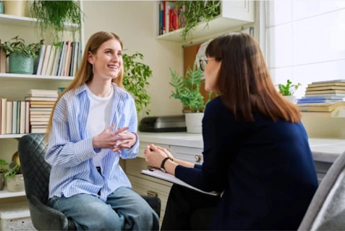 2 women talking in front of a desk