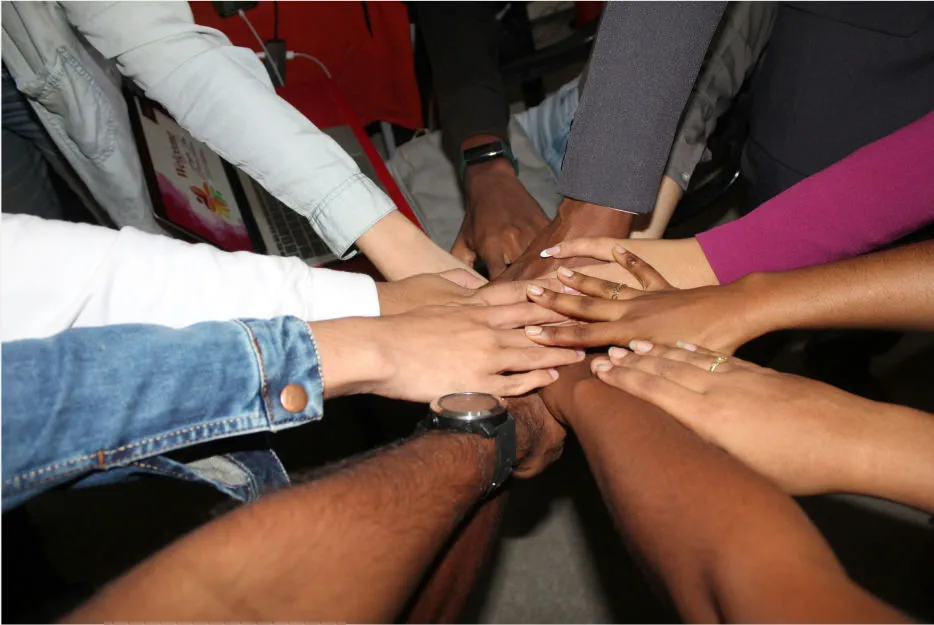 a group of people huddled and their palms together in the center