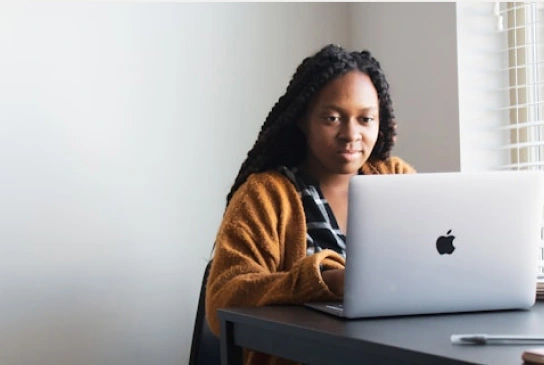 a woman sitting on her desk using her laptop