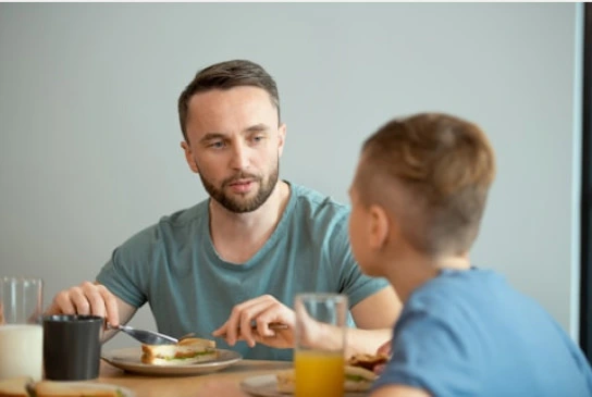 a father and son eating on a table