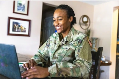 a military person using her laptop