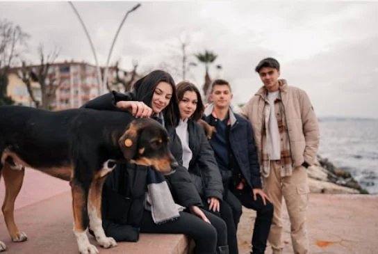 a group of young people together with a dog